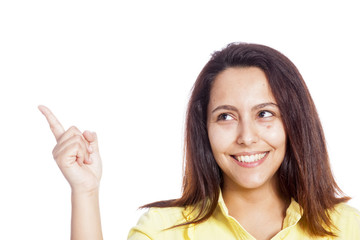 Smiling young casual woman pointing her finger to copy space
