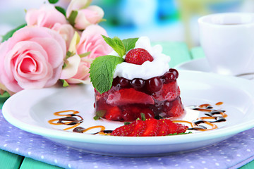 Tasty jelly dessert with fresh berries, on bright background