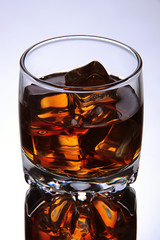 Brandy glass with ice on grey background