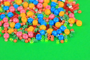 Fototapeta na wymiar Different colorful beads on green background