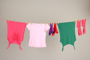 Laundry line with clothes on wall background