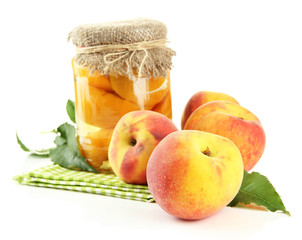 Jar of canned peaches and fresh peaches, isolated on white