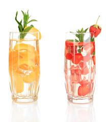 Glasses of fruit drinks with ice cubes isolated on white