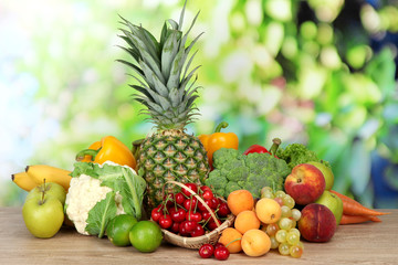Naklejka na ściany i meble Assortment of fresh fruits and vegetables on natural background