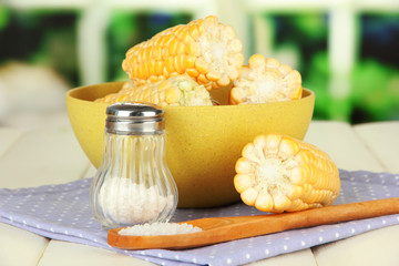 Boiled corn in bowl, on wooden  table, on bright background