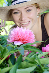 Junge Gärtnerin mit Rhododendron-Blüte im Garten
