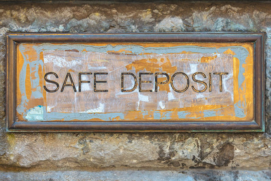 Weathered copper bank placard with the text safe deposit