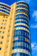 Fototapeta na wymiar High-rise building on a background of blue sky