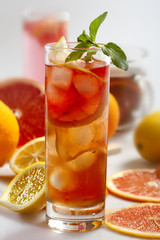 Fresh and cold ice tea with sliced grapefruit, lemon and mint