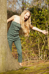 Obraz premium Funny happy young blonde girl in green park.