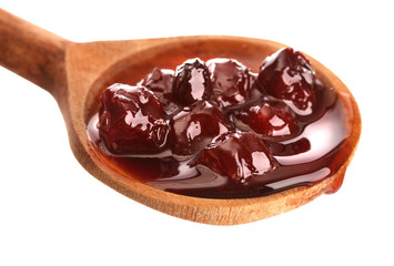 tasty berry jam in wooden spoon, isolated on white