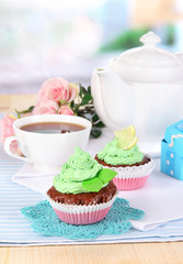 Beautiful cupcakes on dining table on room background