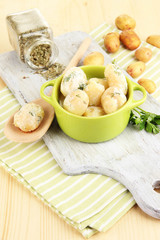Tender young potatoes with sour cream and herbs in pan