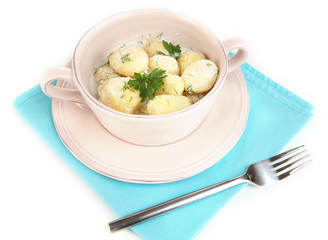 Tender young potatoes with sour cream and herbs in pan isolated