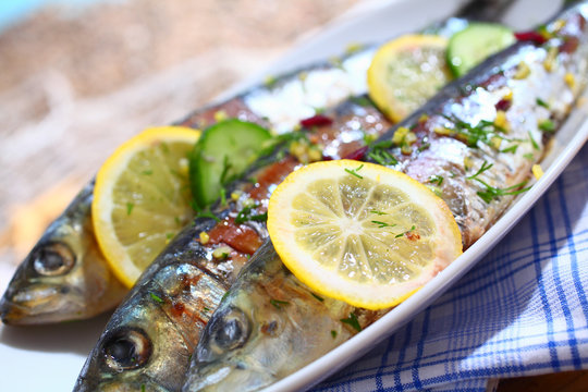 Close-up of grilled sardines on a platter outdoors