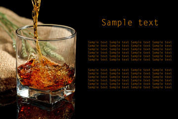 Whiskey glass and bottle on a black