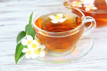 Cup of tea with jasmine, on wooden table, close-up