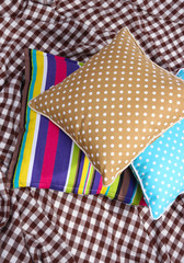 Obraz premium Three various pillows on plaid