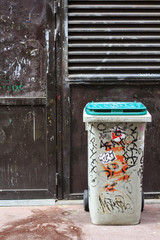Old garbage bin stained with dirt and graffiti