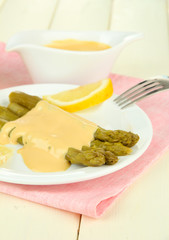Asparagus on plate, on wooden background