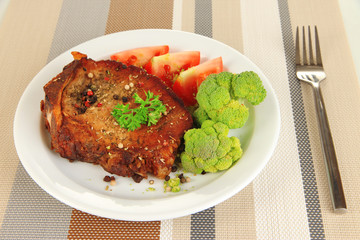 Piece of fried meat on plate on napkin close-up