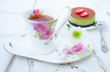 Obraz na płótnie Canvas Tiramissu cake - green tea - with strawberries and a cup of tea