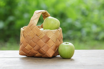 green apples in a birchbark basket