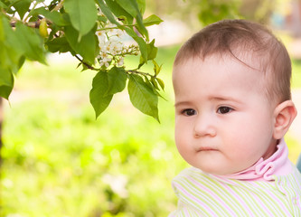 Thoughtful child near a blossoming cherry