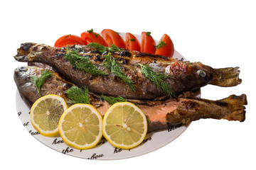 Fried trout with tomatoes and lemon isolated on white background