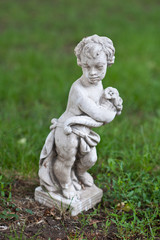 Statue of a child angel in prayer made from white stone