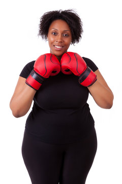 Overweight young black woman holding boxing gloves - African peo