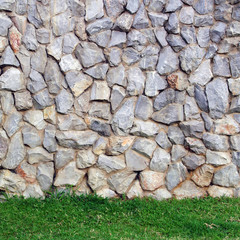 Rocks wall  on Fresh green grass background