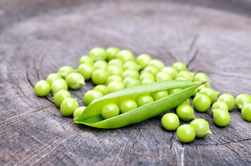 Fresh green peas on an old wooden background