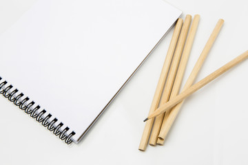 Notebook and pencils on white background