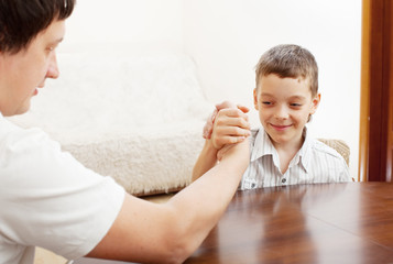 Father and son arm wrestling