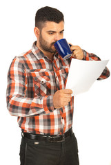 Man drink coffee and holding paper