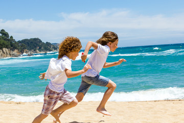 Fototapeta na wymiar Two boys running on beach.