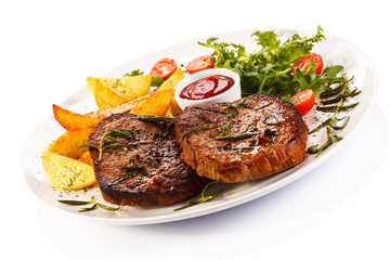 Grilled steaks, baked potatoes and vegetables