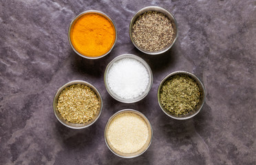 Herbs and spices in round pots on slate tile