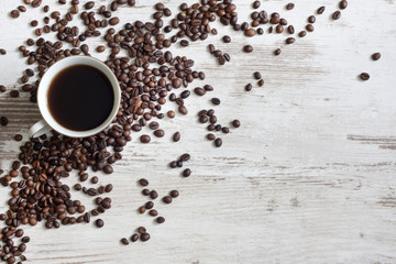 Cup of coffee with beans on retro vintage white planks concept