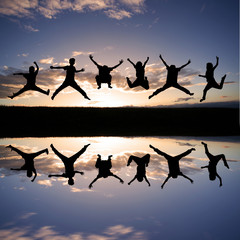 silhouette of kids jumping in sunset