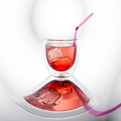 Red cocktail with ice cubes