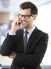 Smiling businessman talking on a mobile phone.