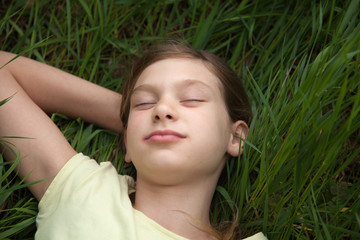 Mädchen entspannt auf einer Wiese in der Natur