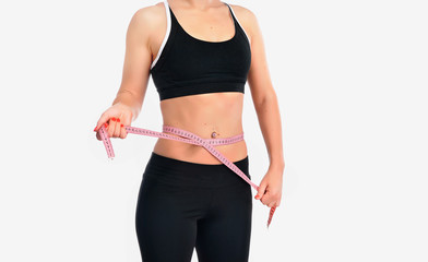Young fitness woman measuring her waist
