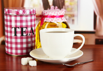 Obraz na płótnie Canvas Jar and cup of tea on table in room