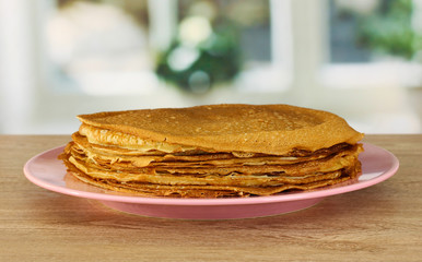 Sweet pancakes on plate on table in kitchen