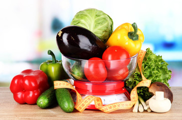 Fresh vegetables in scales on table in kitchen