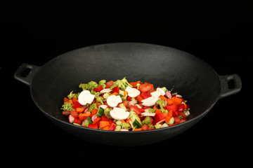 Vegetable ragout in wok, isolated on black