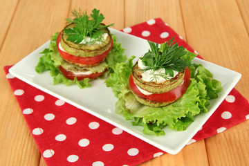 Tasty roasted marrow and tomato slices with salad leaves,